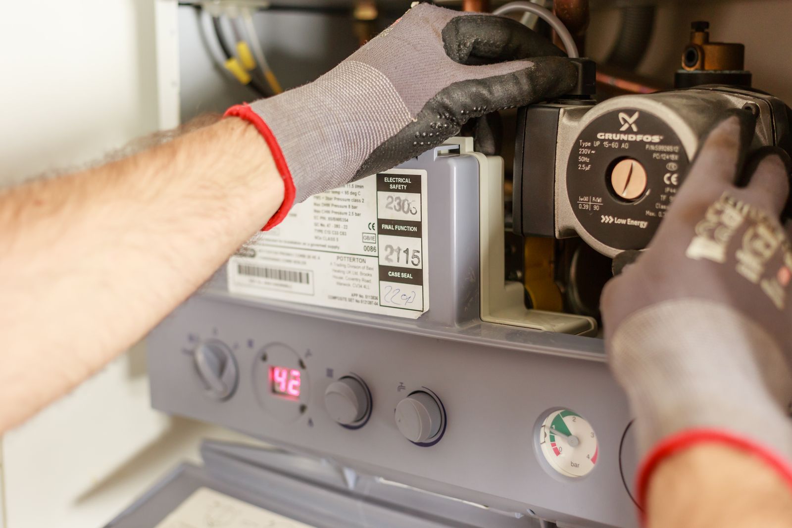 Technician servicing the internal components of a home heating system, by London HVAC Pros